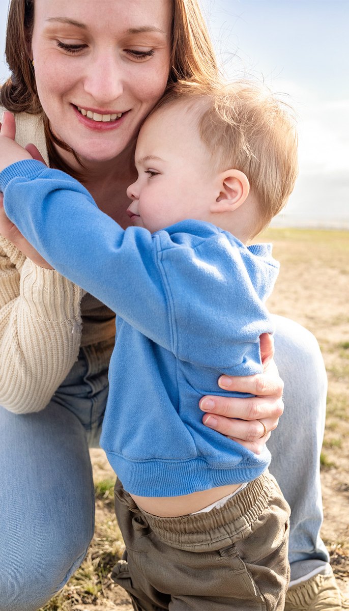 Mother embracing her child outdoors